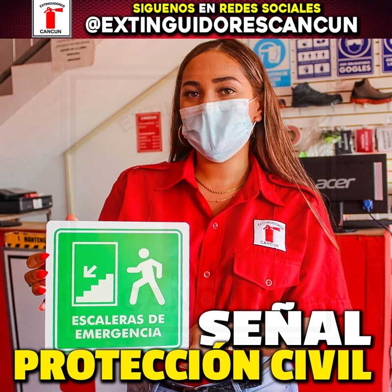 Una mujer con máscara sostiene un cartel que dice escaleras de emergencia.