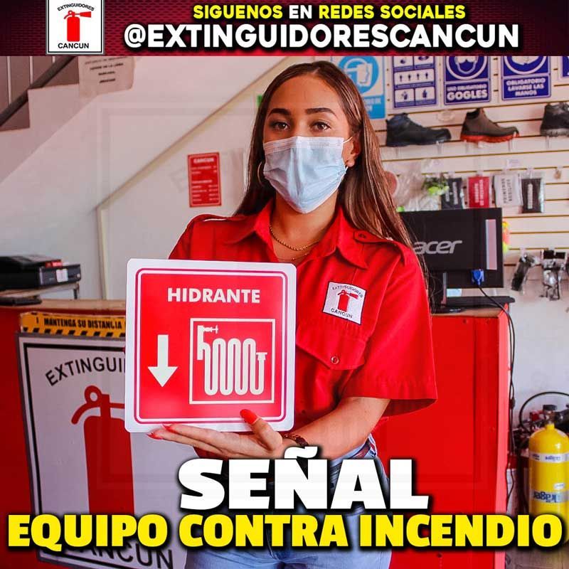 Una mujer con mascarilla sostiene un cartel que dice hidrante 5000