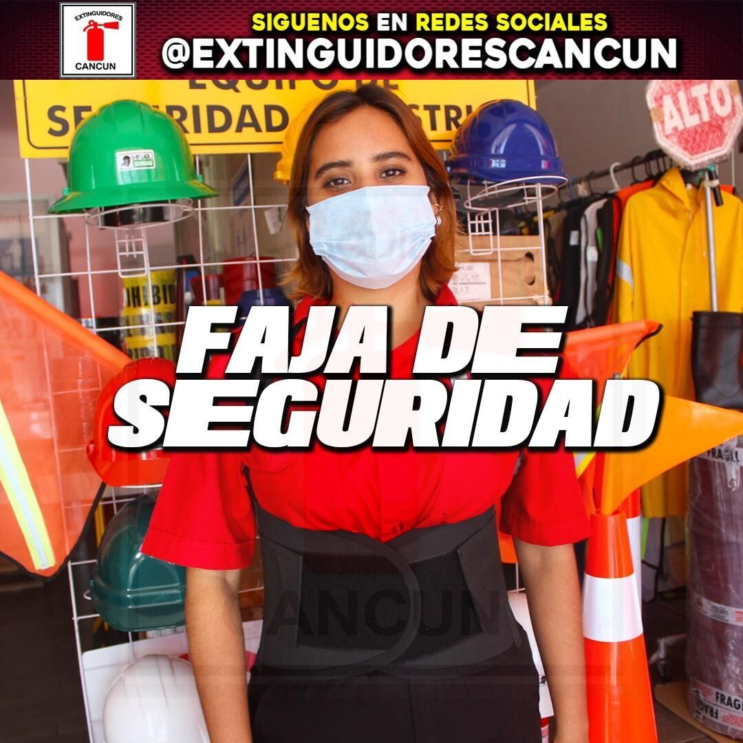 Una mujer con mascarilla se para frente a un cartel que dice faja de seguridad