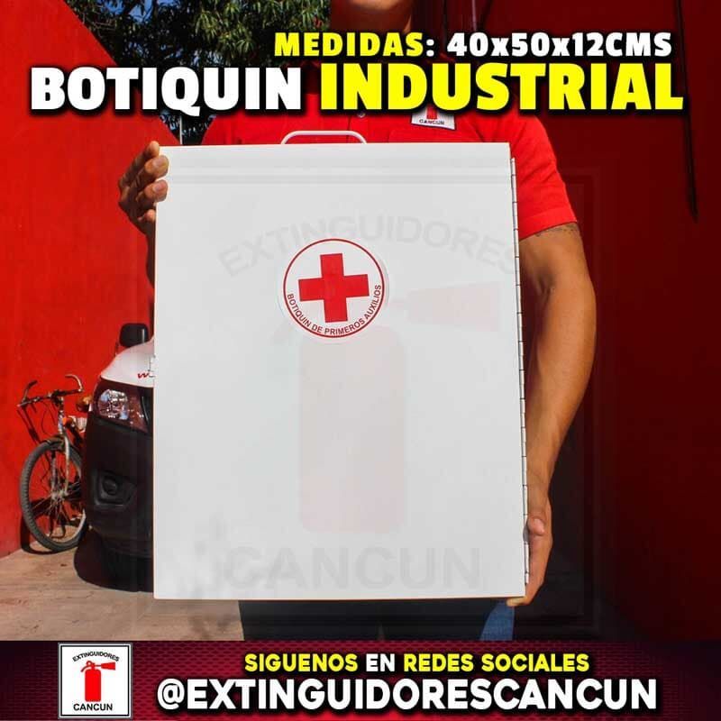 Un hombre con una camisa roja sostiene una caja blanca con una cruz roja.
