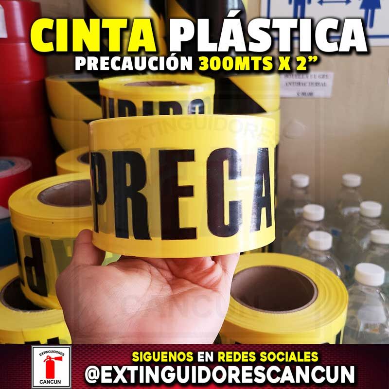 Una persona sostiene un rollo de cinta amarilla que dice precaución.