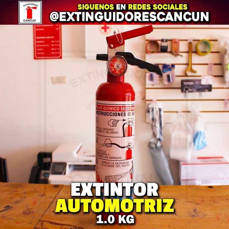 Un extintor de incendios rojo está sentado sobre una mesa de madera