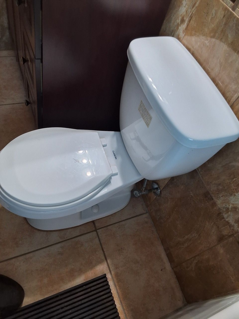 White toilet in a tiled bathroom, viewed from above.