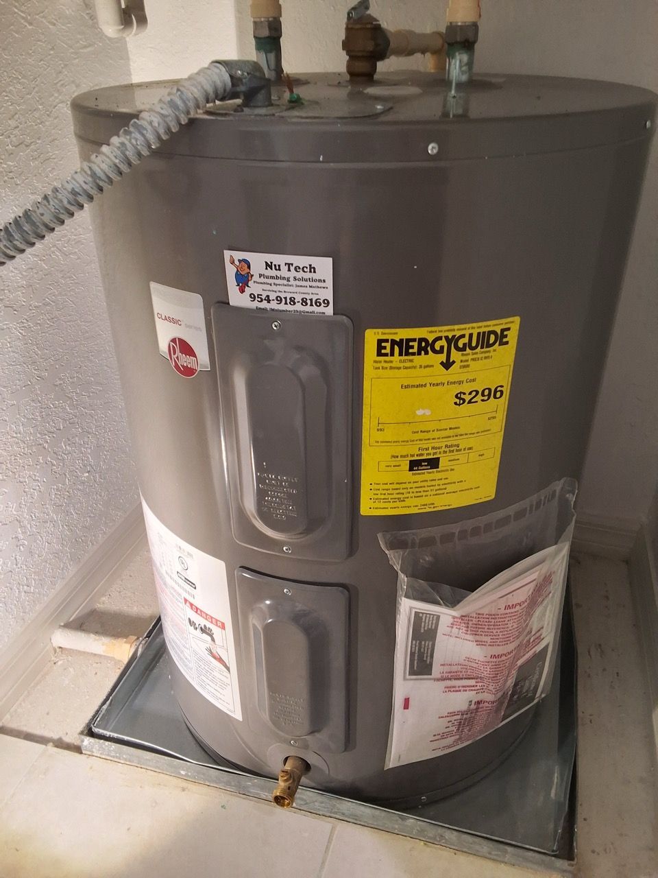 Gray water heater with yellow EnergyGuide label in a utility room