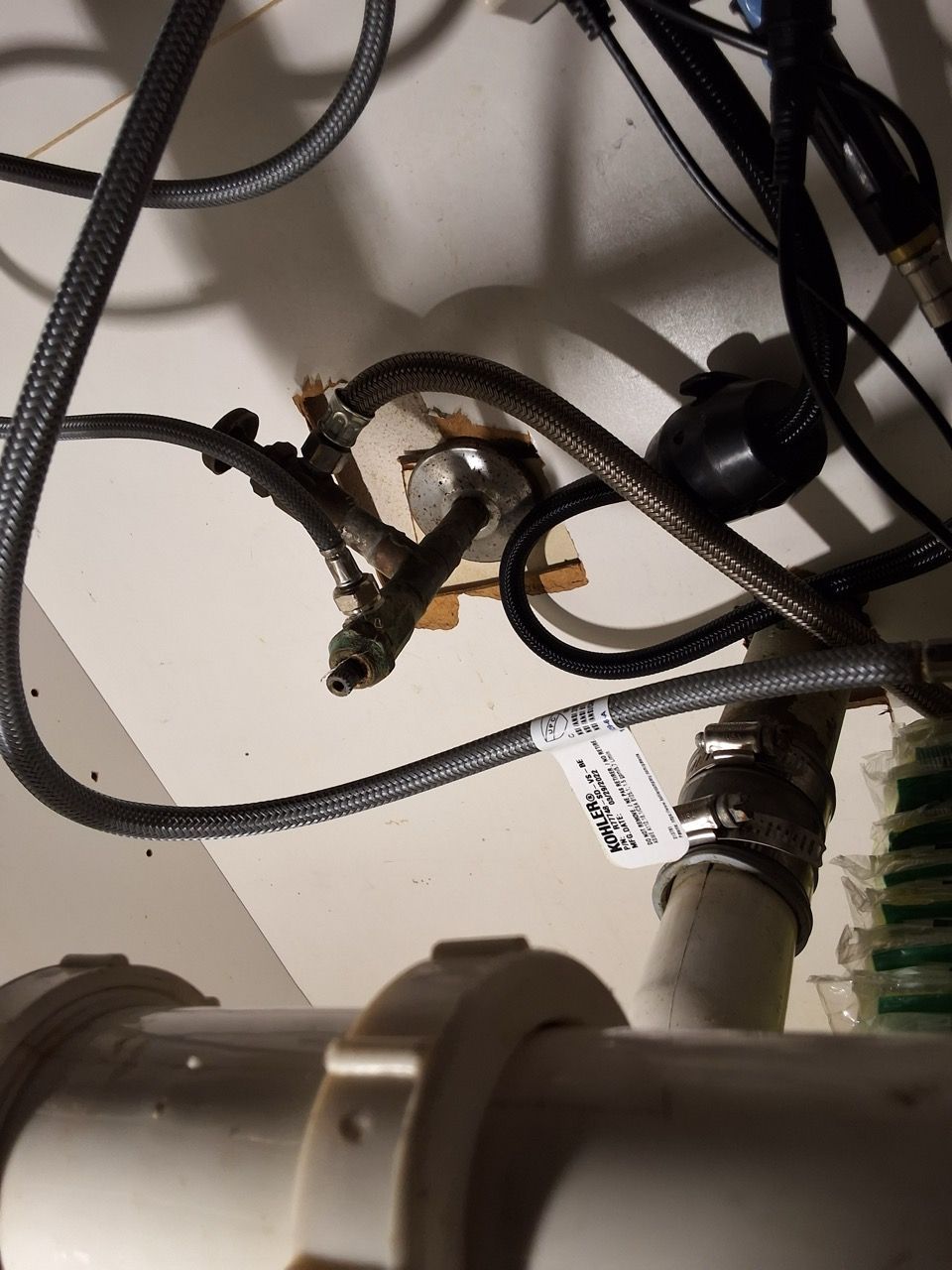 Close-up of tangled black cables and connectors on a light surface, with a metal fixture at the bottom.