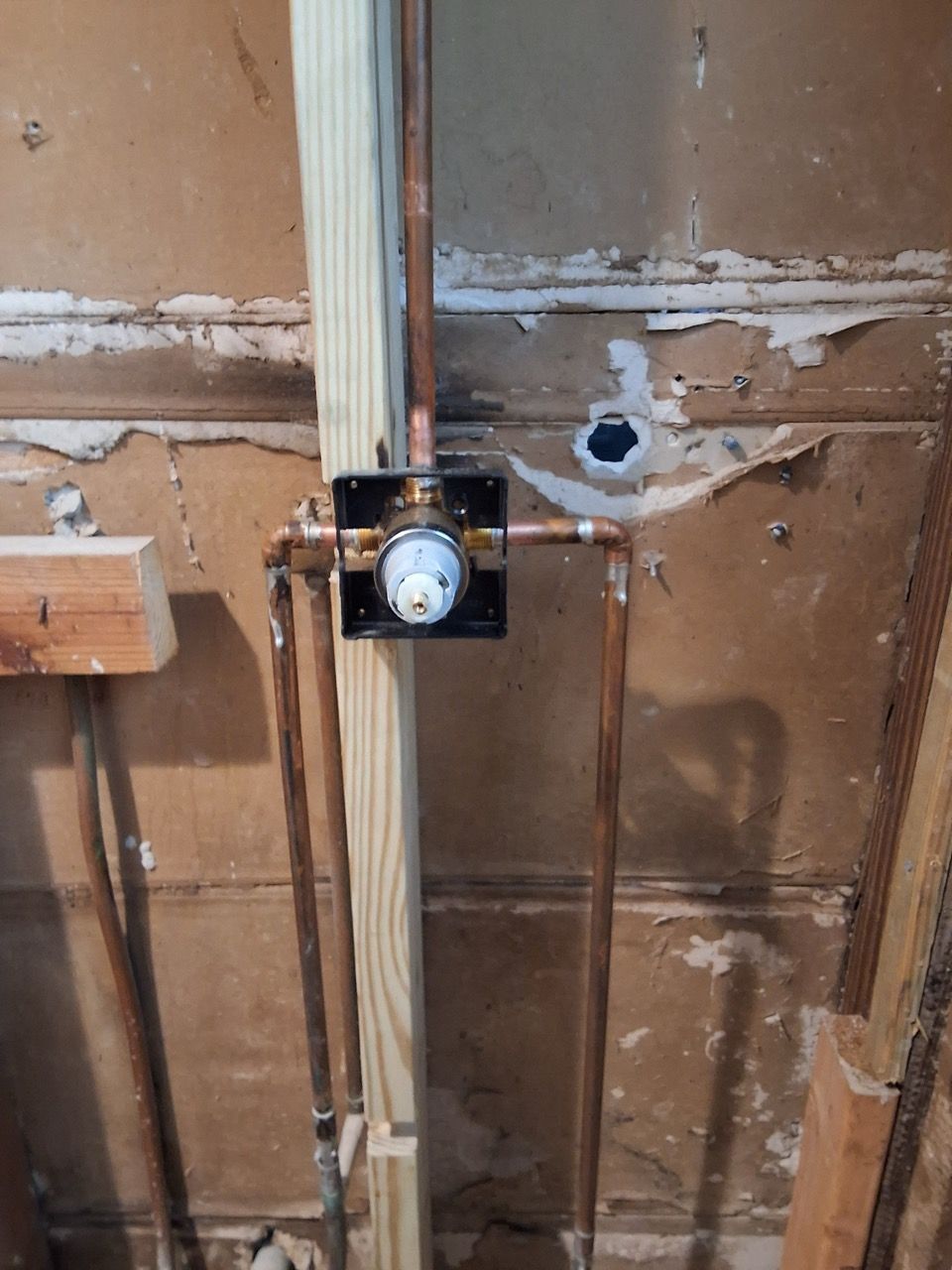 Exposed wall studs with a mounted electrical box and wiring during renovation