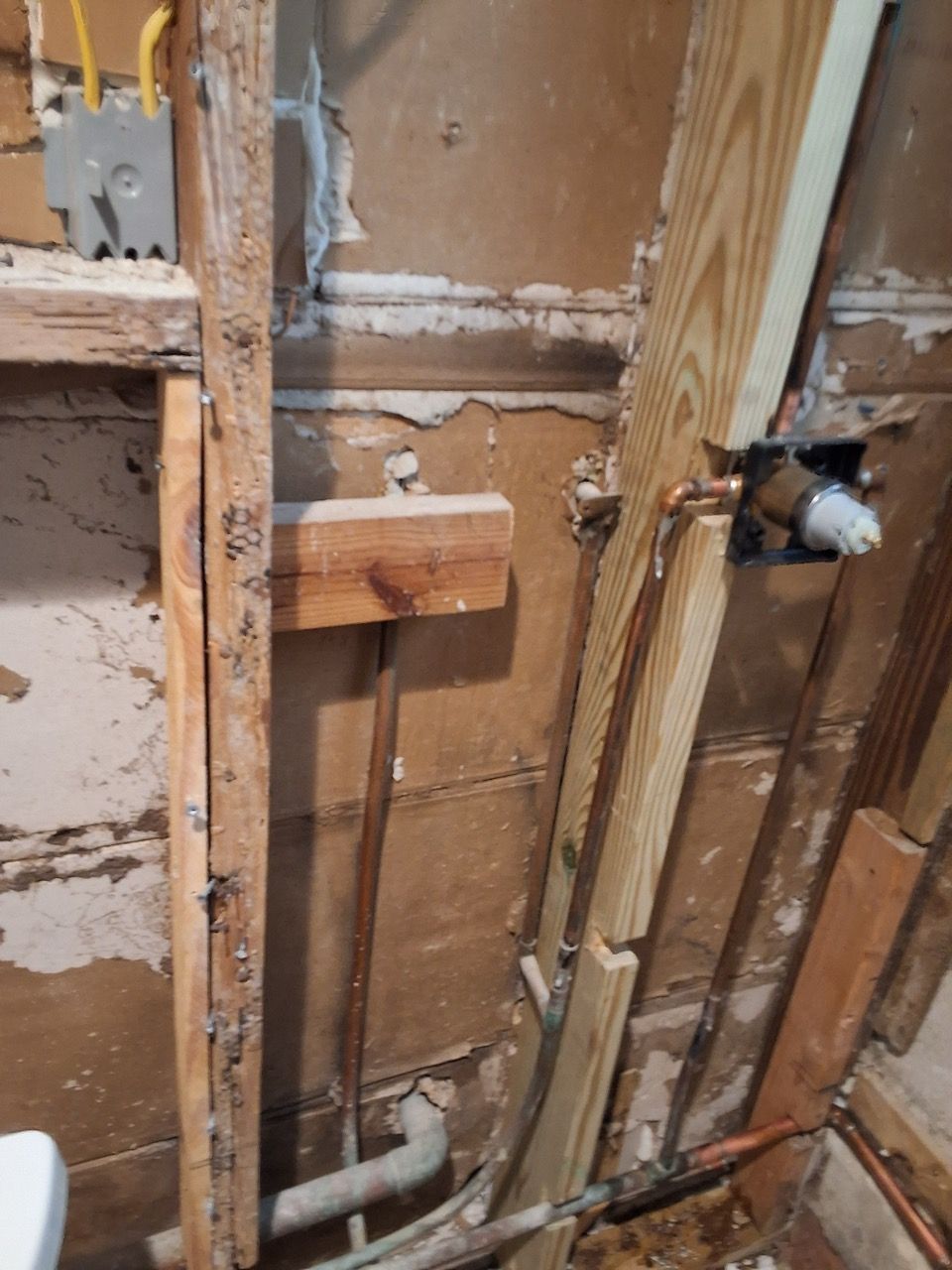 Exposed wall studs and plumbing in a stripped interior during renovation