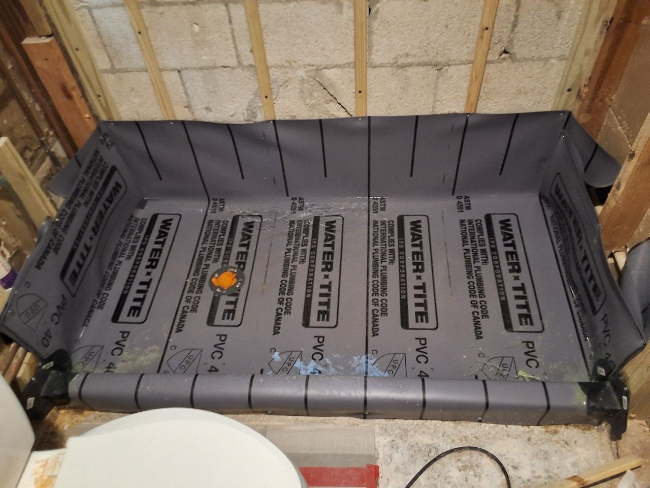 Gray insulation board installed in a framed wall alcove under construction