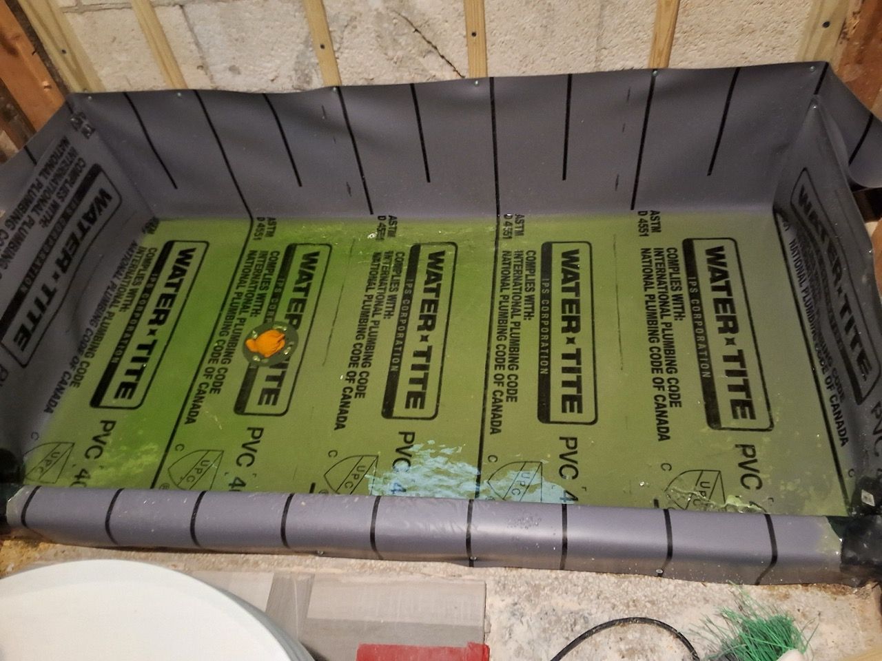 Insulated floor with green water-resistant underlayment panels inside a framed room