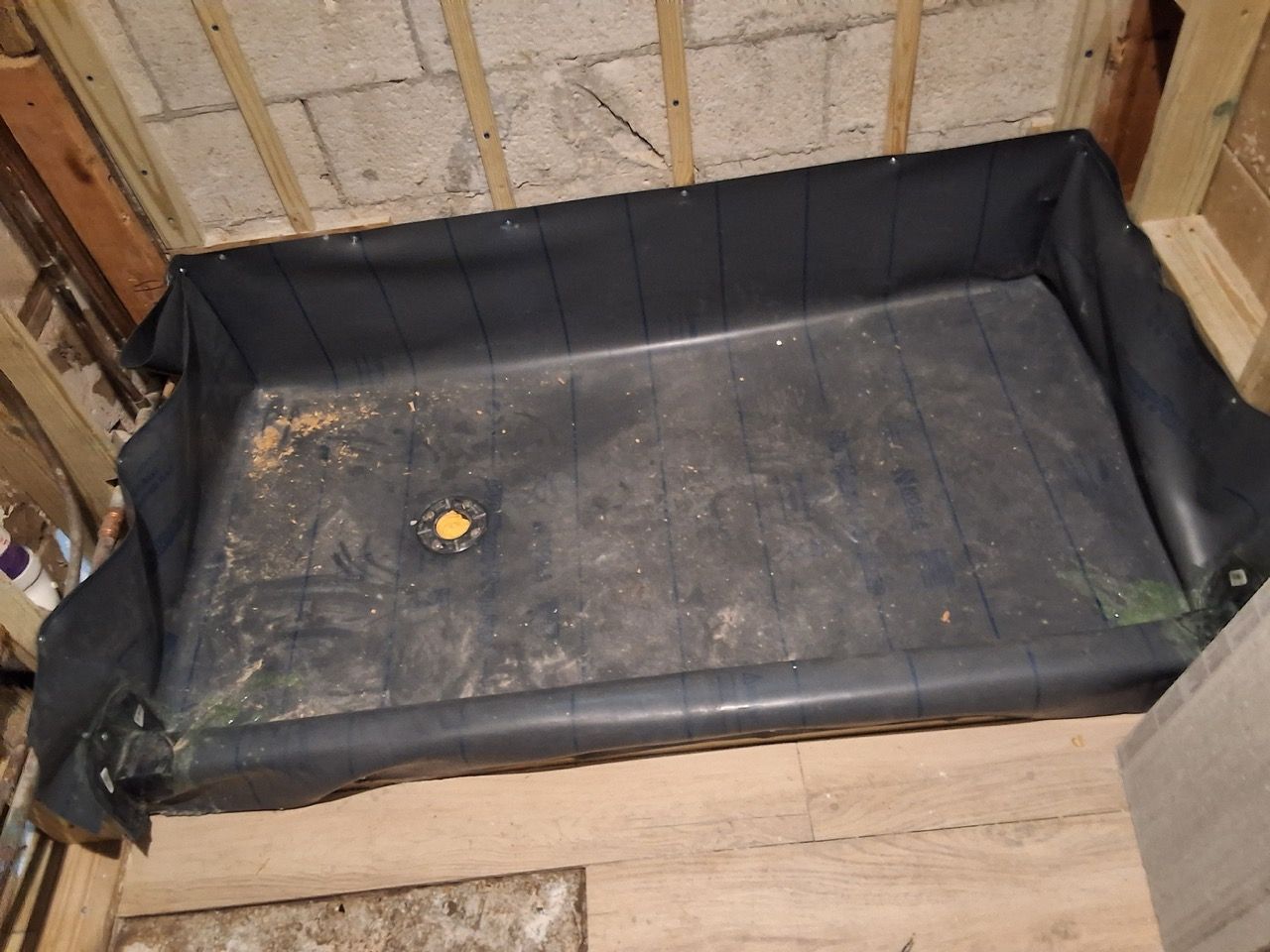 Black-lined wooden pet pen with a dirty white floor and a small yellow toy inside.
