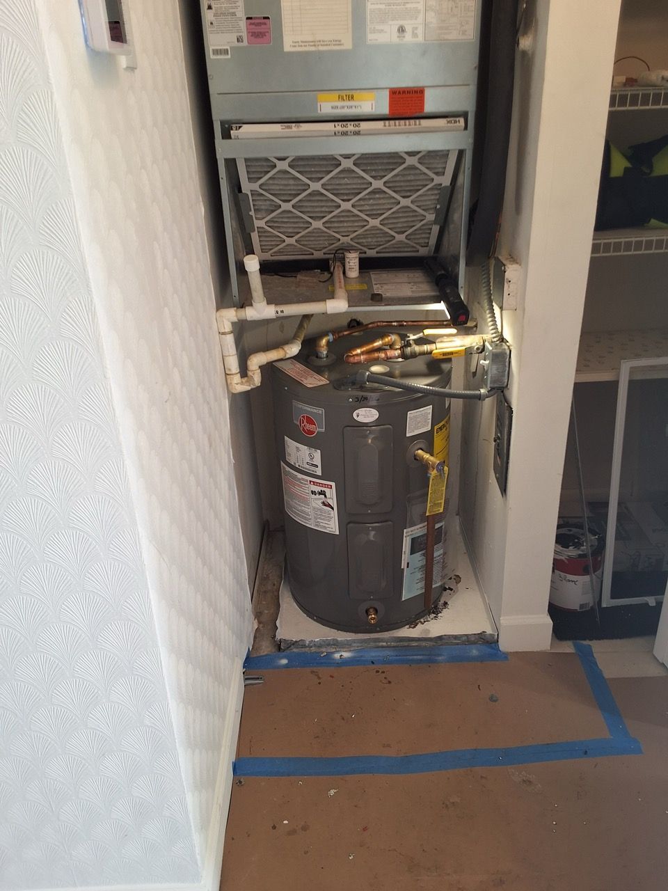 Open utility closet with a water heater and exposed HVAC equipment inside.