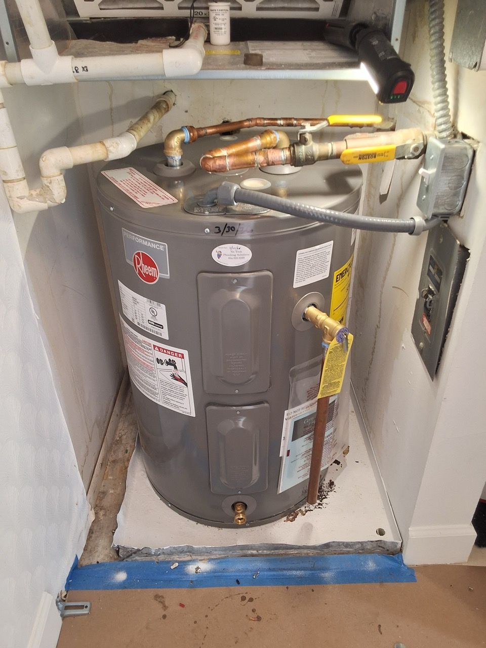 Three white water filters mounted on copper pipes with gauges in a utility room.
