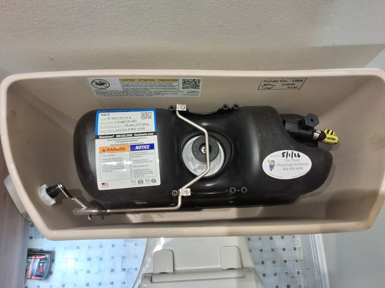 Black water pump unit mounted inside a beige rectangular tank.