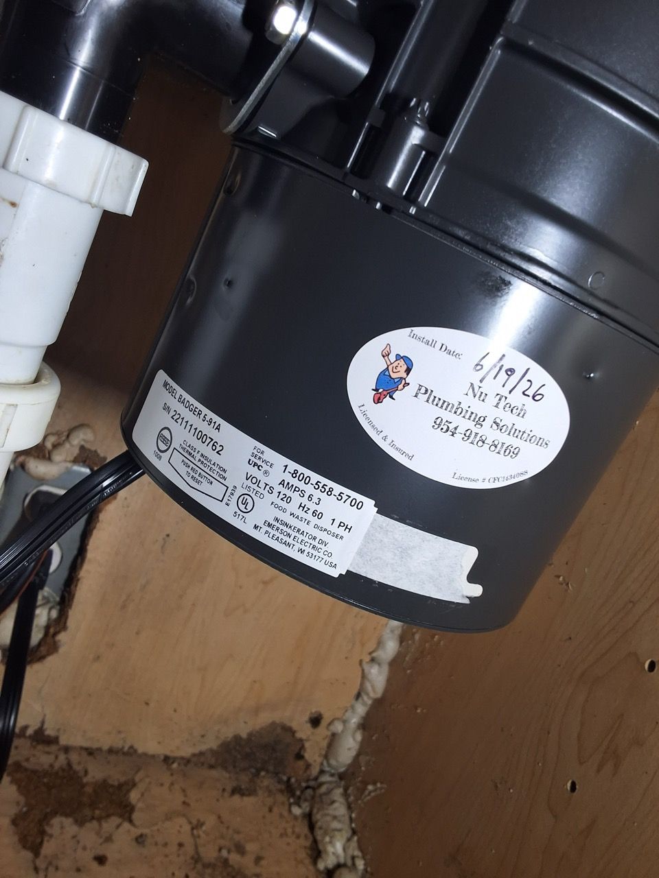 Blue water filters mounted on a wall beside outdoor plumbing and pipes in snow