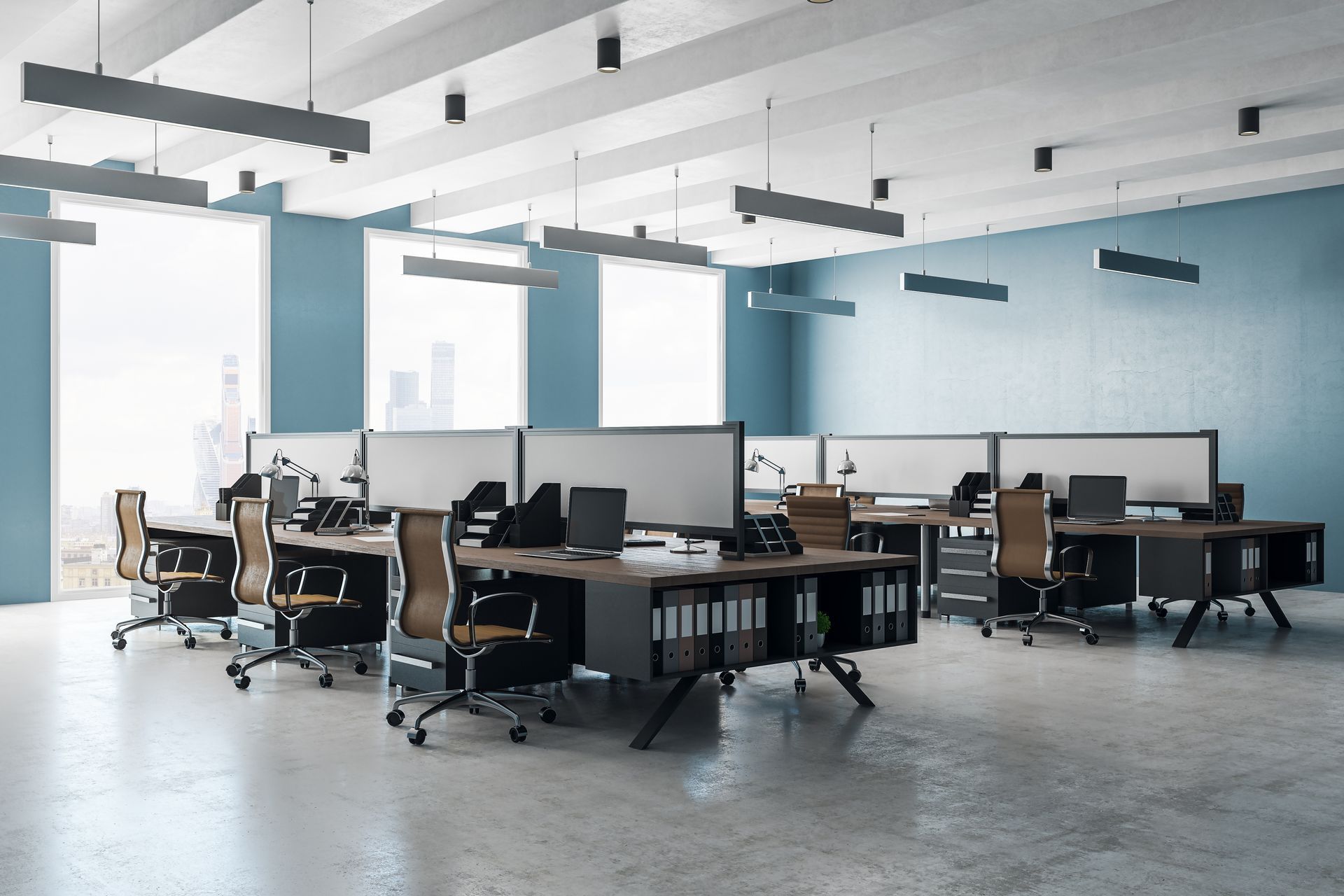 Open-plan office with desks, computers, chairs, and blue wall accents in a bright workspace