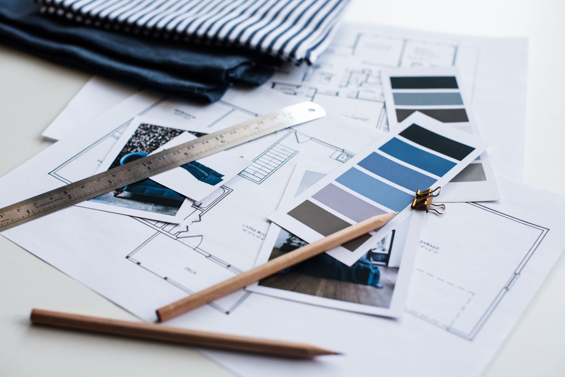 Architect’s desk with blueprints, fabric swatches, ruler, pencils, and a paint color palette