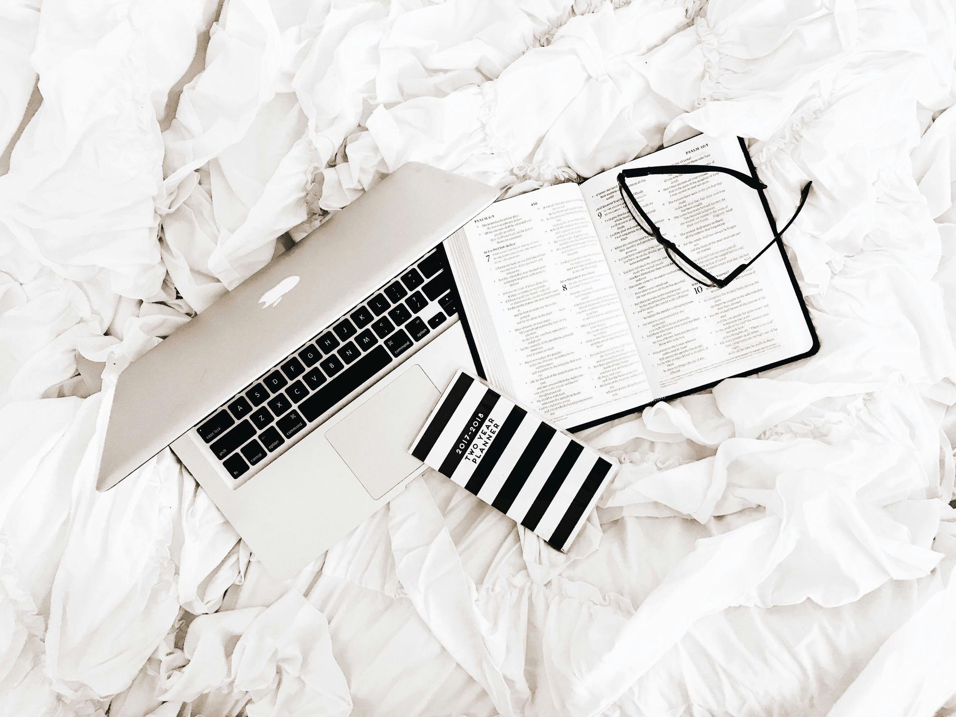 A laptop computer is sitting on top of a pile of crumpled paper.