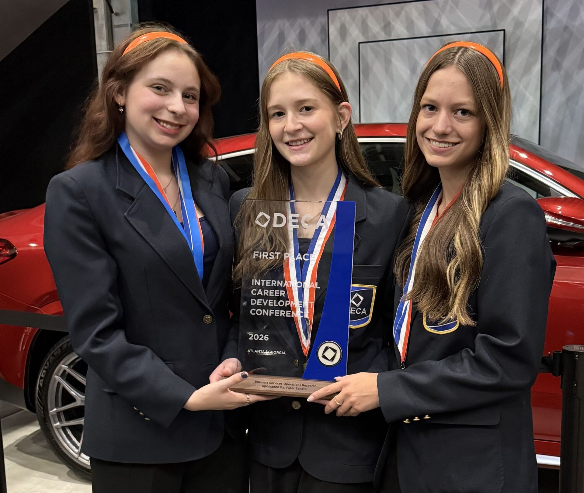 Herriman High School Students holding DECA Award.