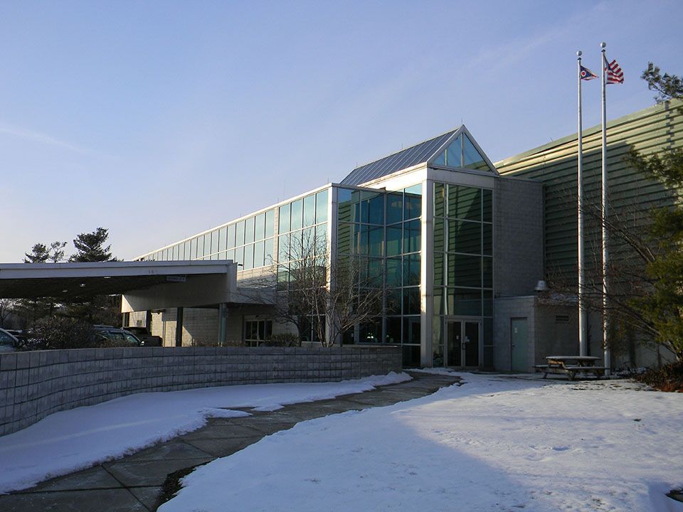A large building with snow on the ground in front of it