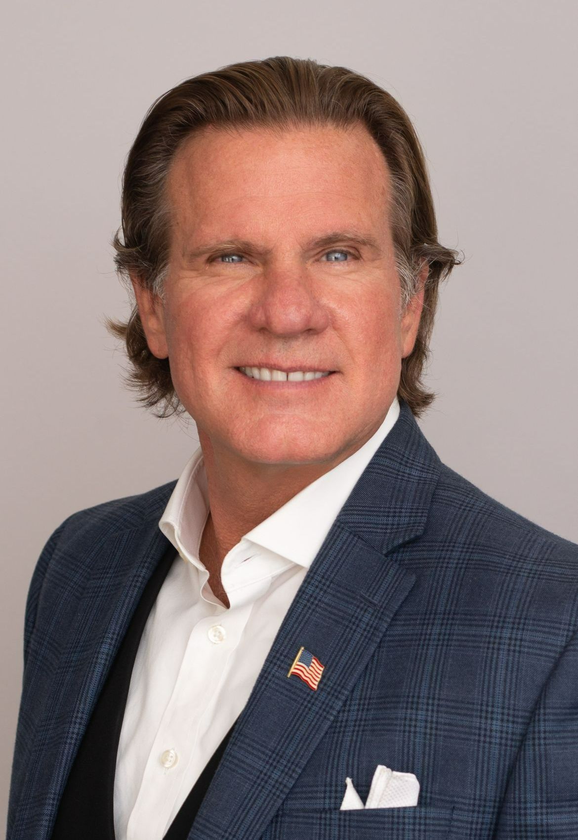 A man in a suit and tie is smiling for the camera.