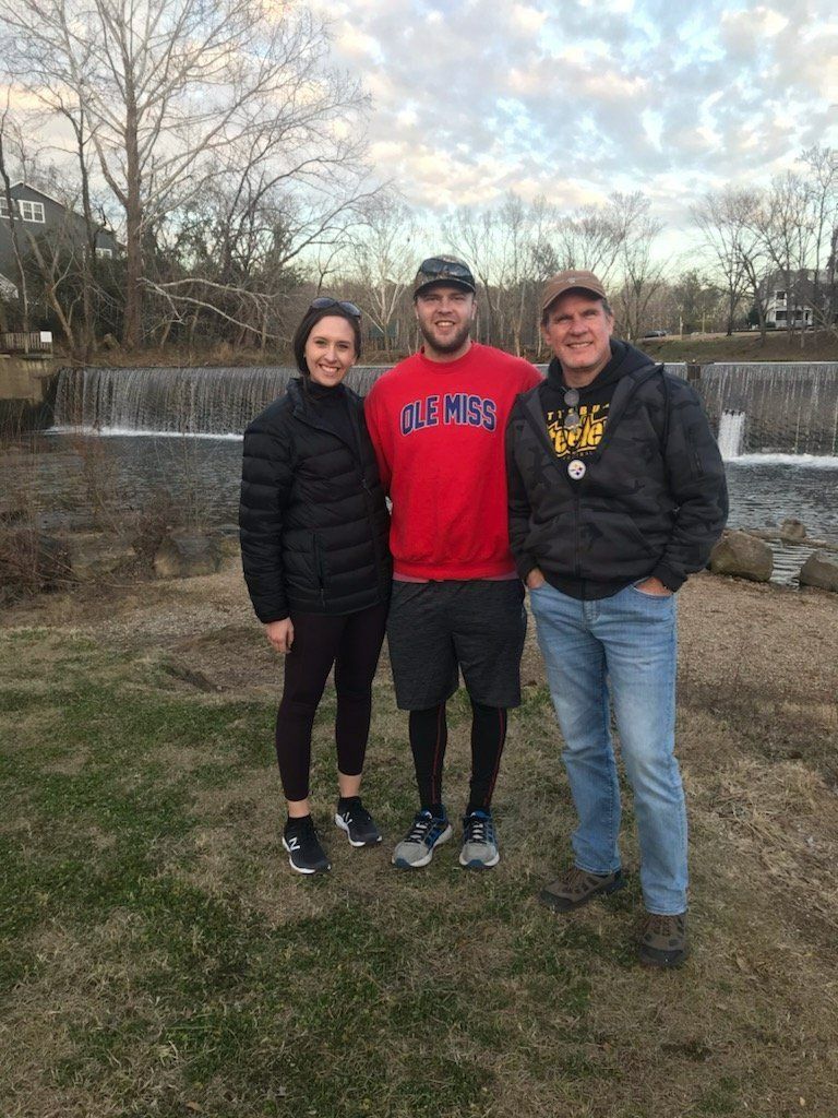 A group of people are standing next to each other in a park.