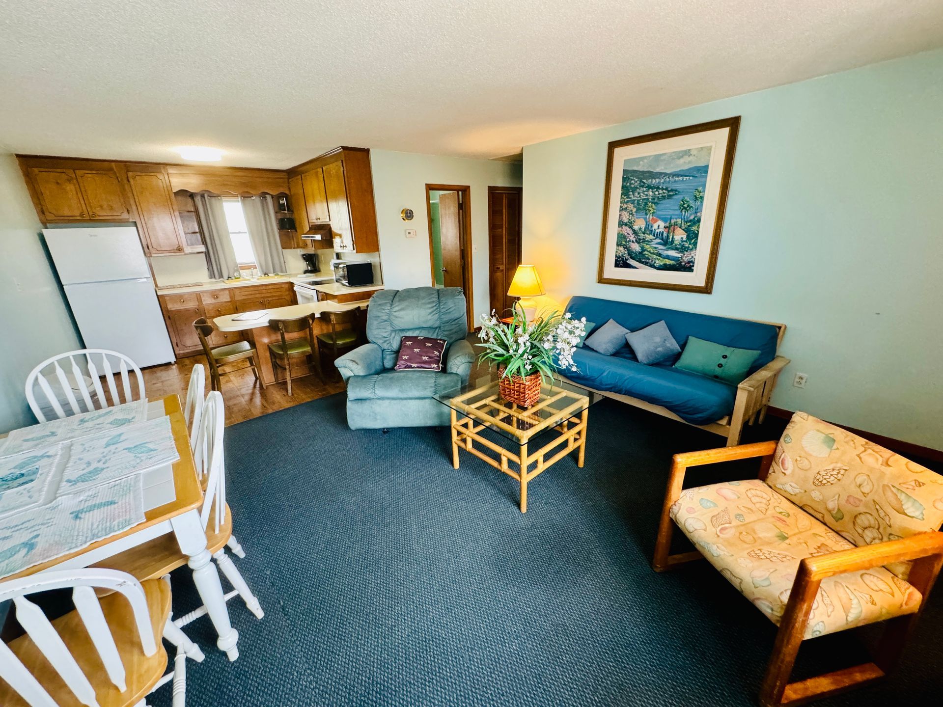 A living room with a couch , chair , table and chairs.