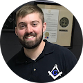 A man with a beard is wearing a masonic shirt and smiling.