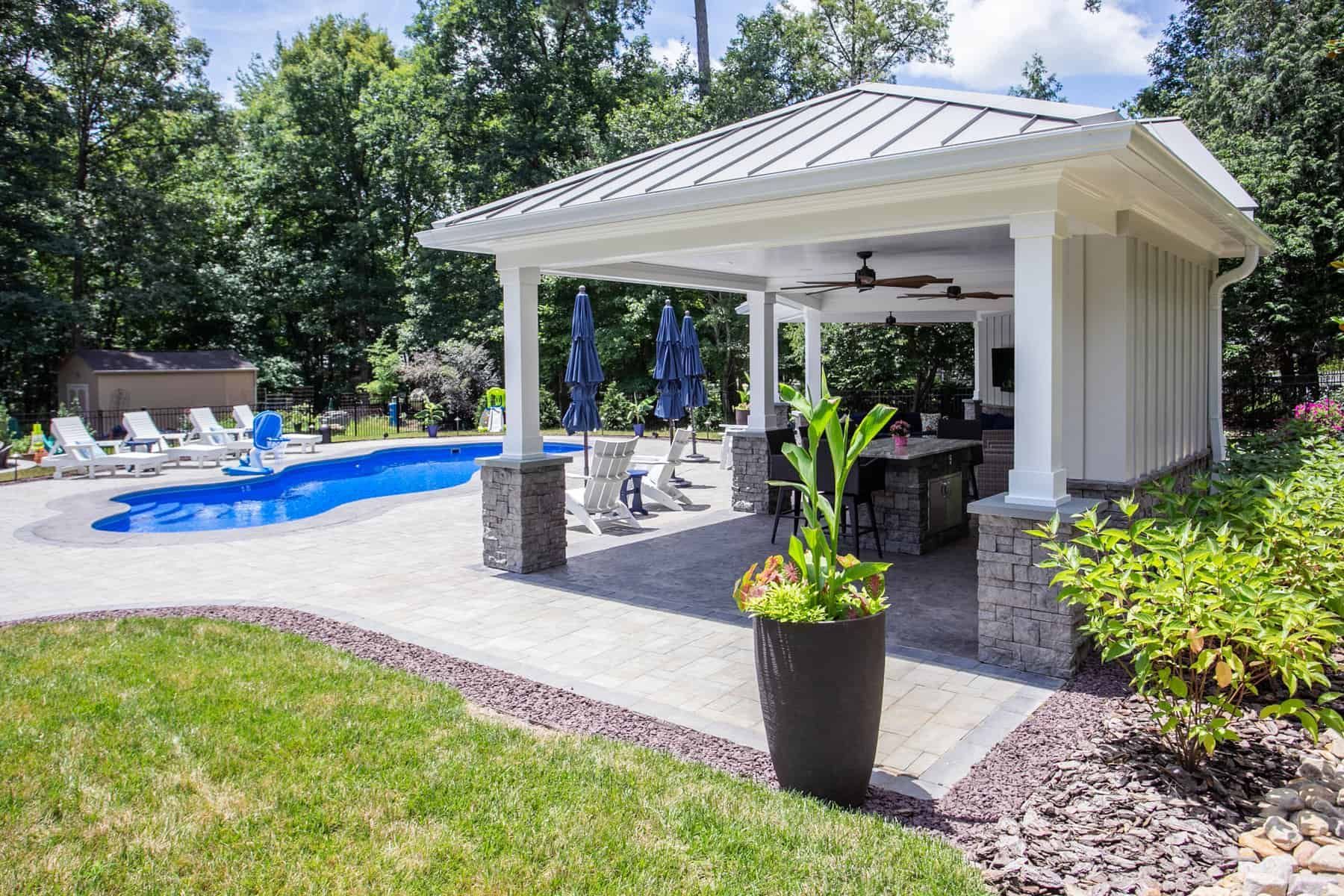 Poolside patio with a pool, gazebo, and lawn.