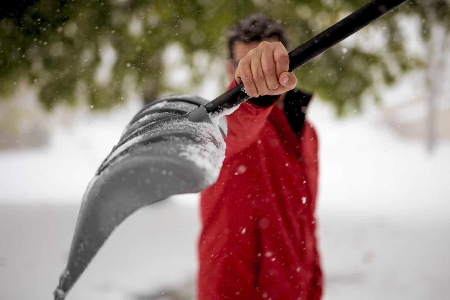 Person in red jacket shoveling snow.