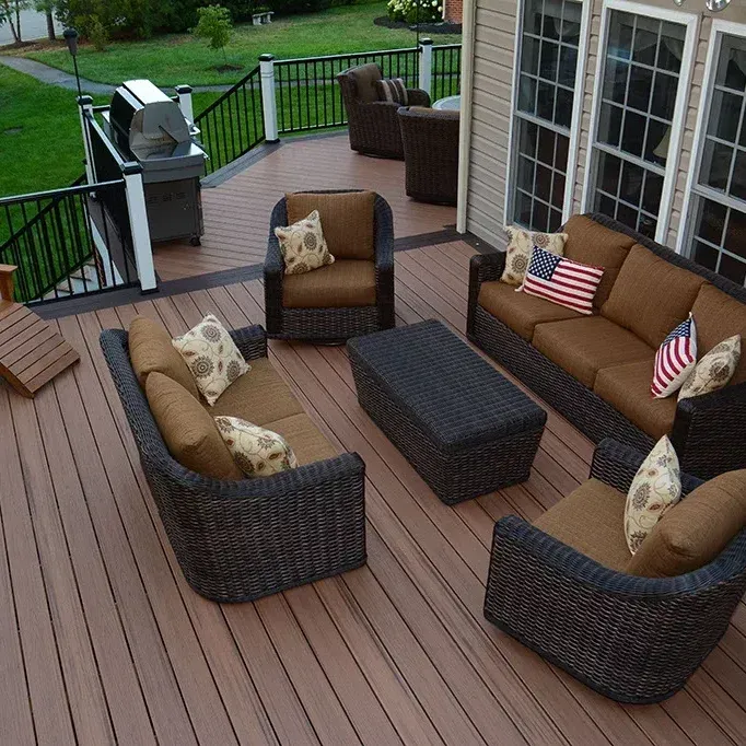 Outdoor deck with brown wicker furniture, sofa, chairs, and coffee table.