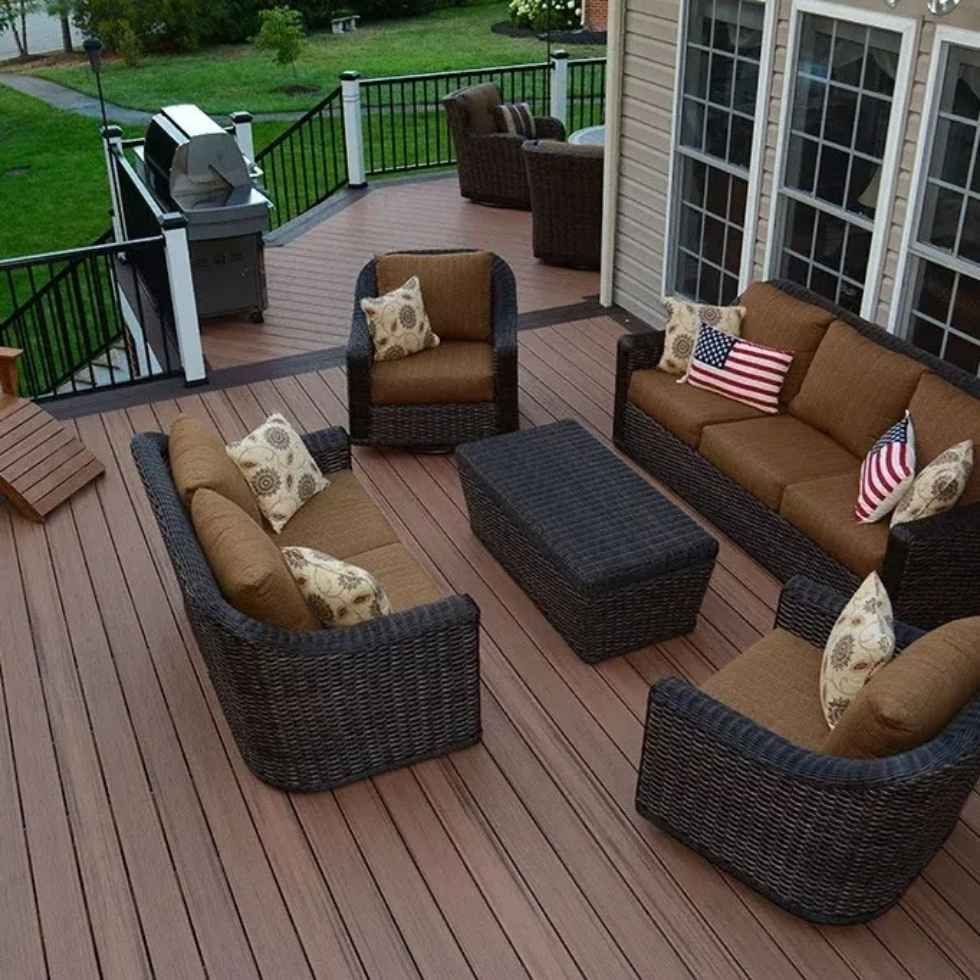 Outdoor deck with brown wicker furniture, sofa, chairs, and coffee table.
