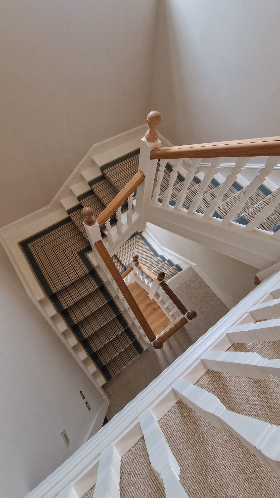Huge winding staircase with Roger Oates stair runner in South Devon