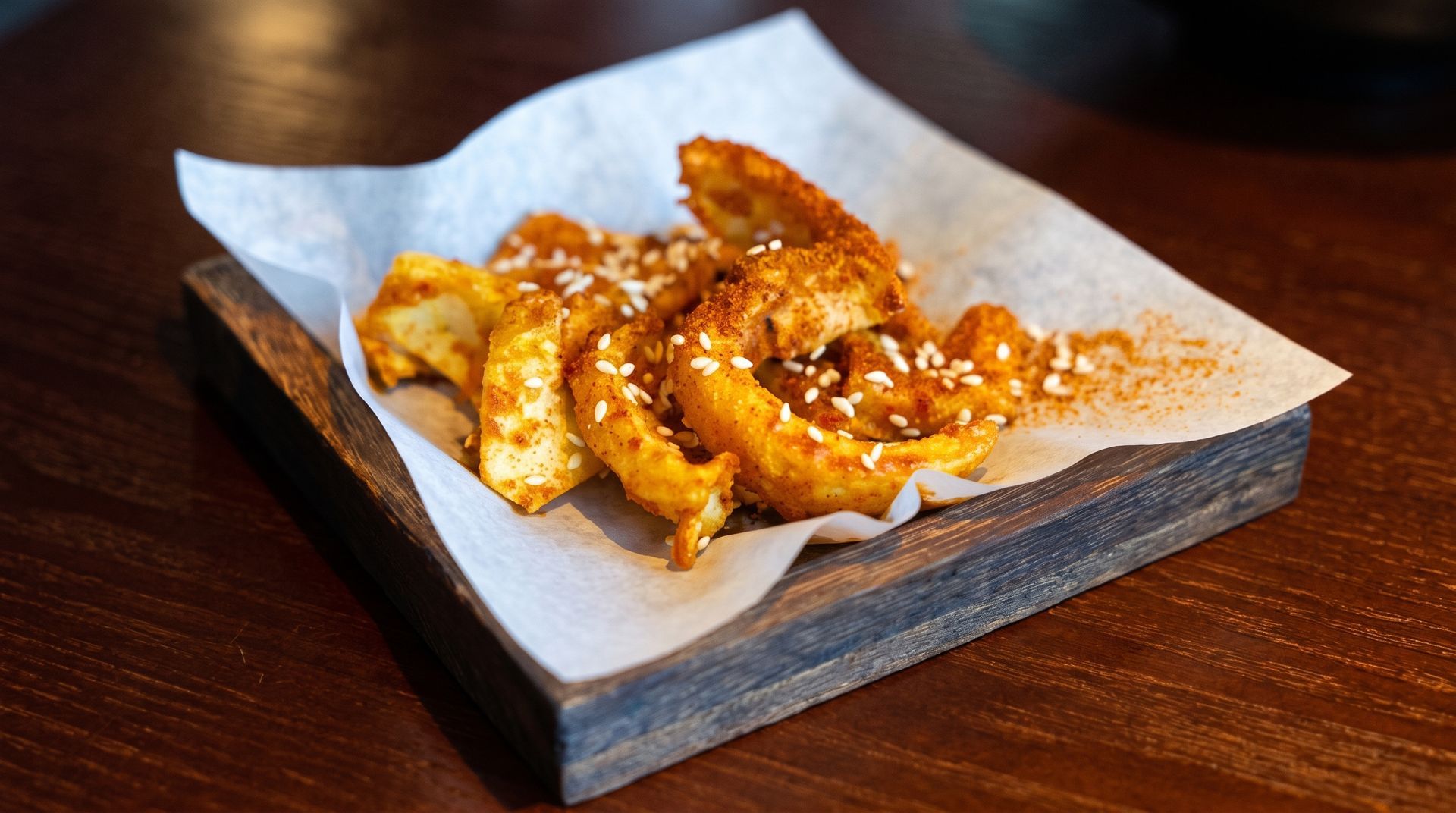 Seasoned fried shrimp on parchment-lined wooden tray
