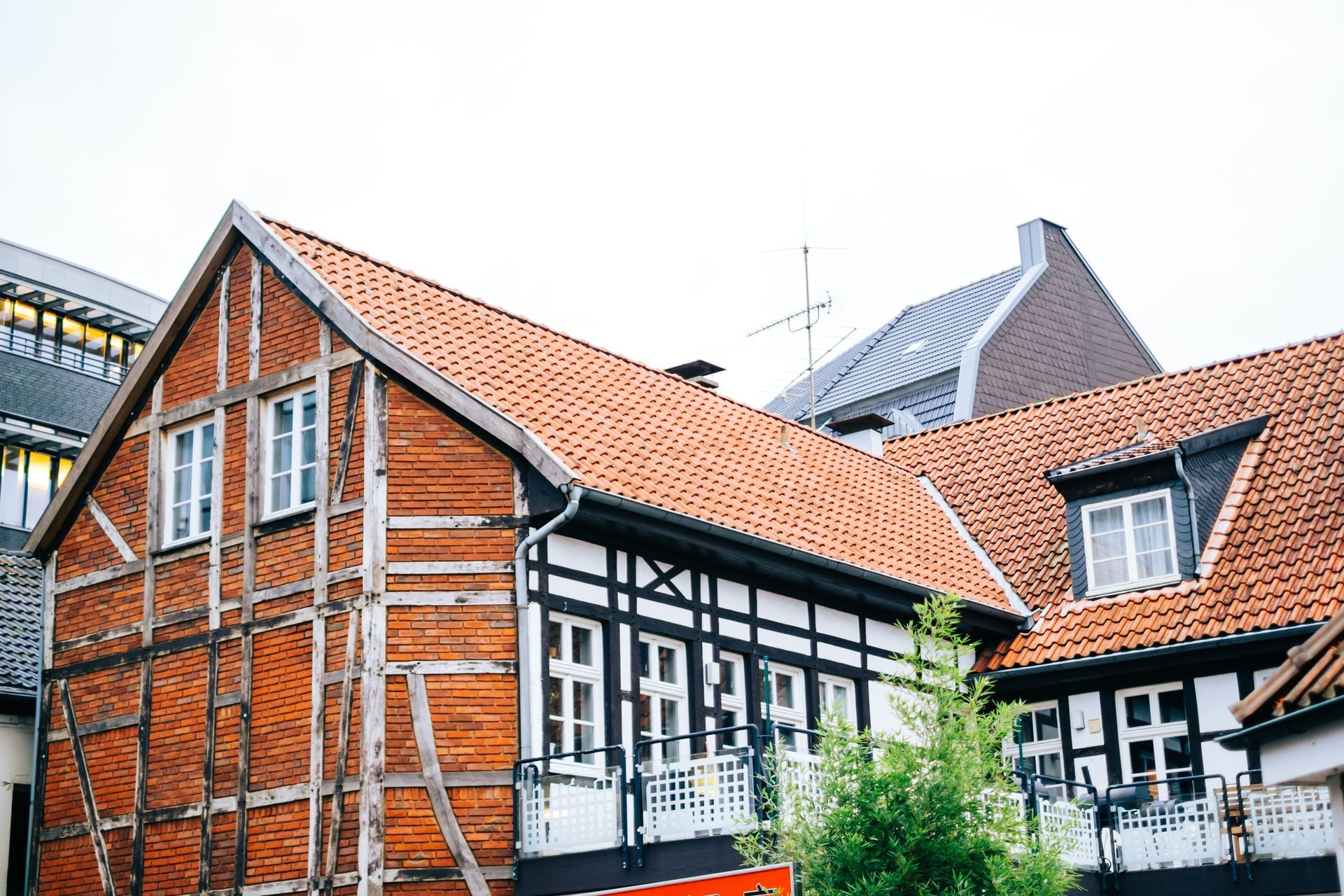 Half-timbered houses with red-tiled roofs. Black and white details, orange wood structure.