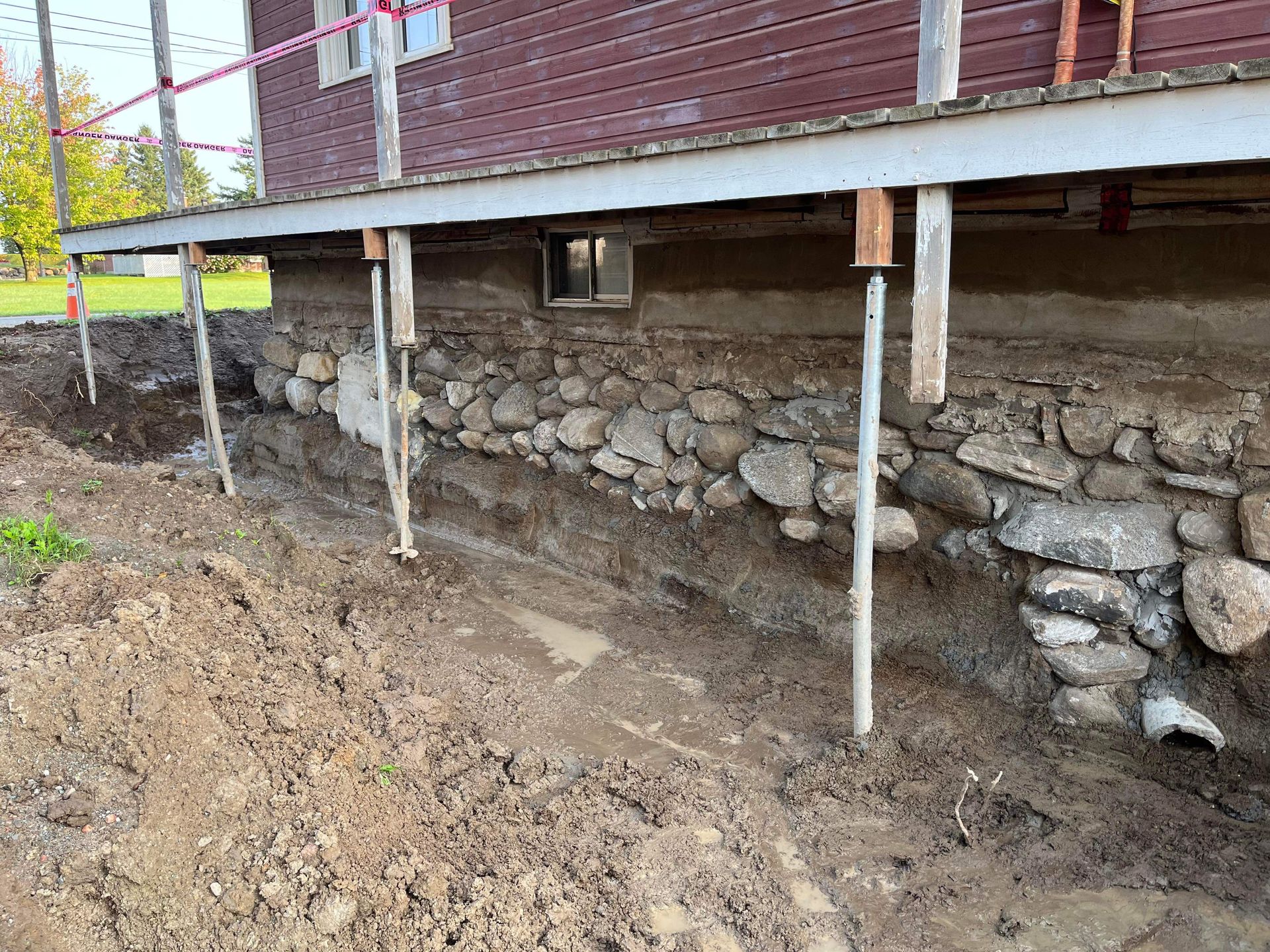 Une maison avec un mur de pierre en dessous est en construction.