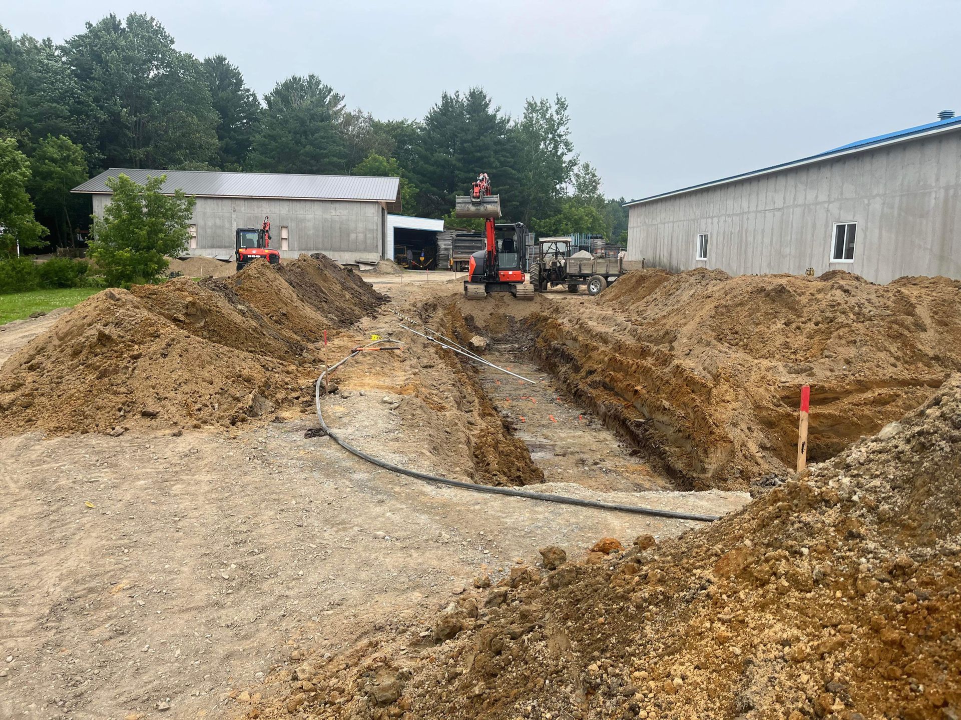 Un chantier avec beaucoup de terre et un bâtiment en arrière-plan.