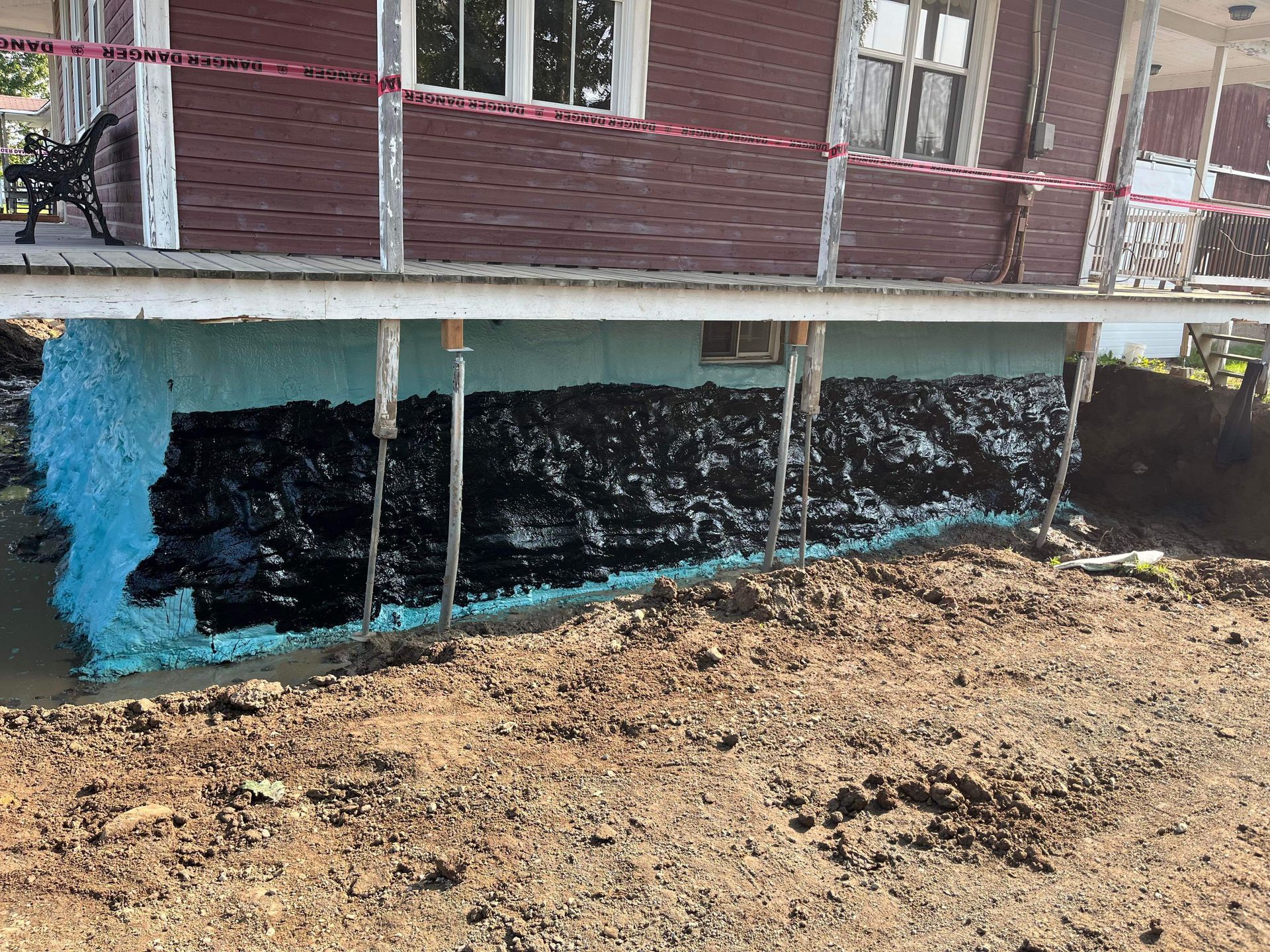 Les fondations d'une maison sont imperméabilisées avec de la peinture noire.