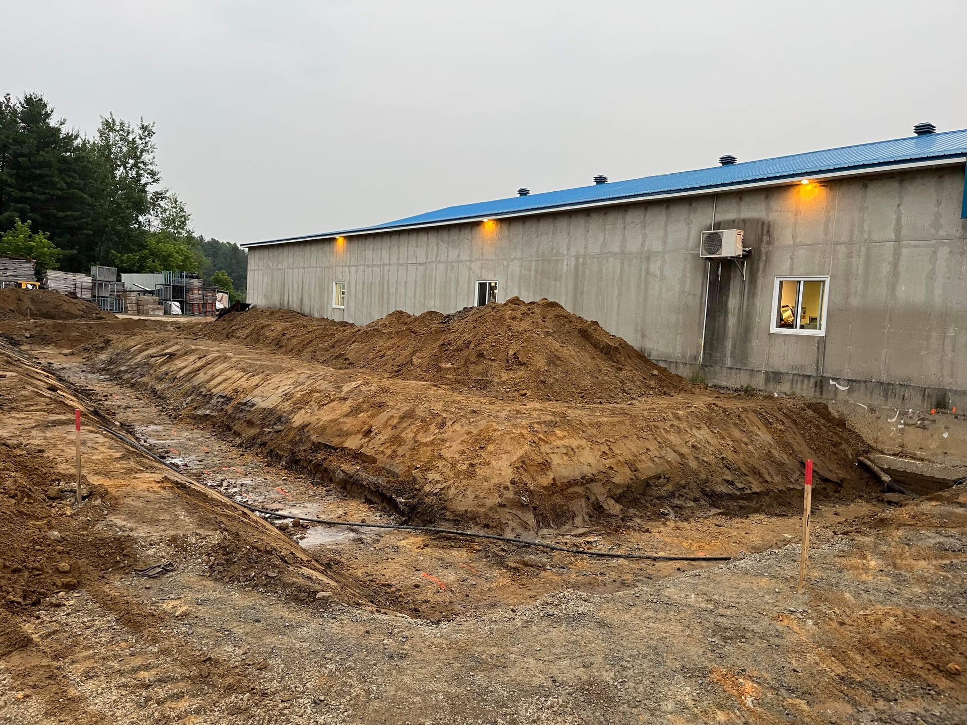 Un gros tas de terre se trouve devant un bâtiment en construction.