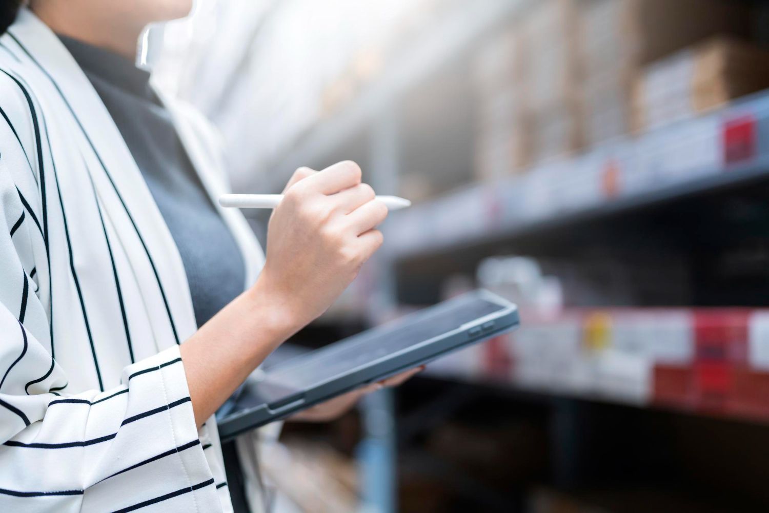 Person using a tablet while shopping in a store aisle