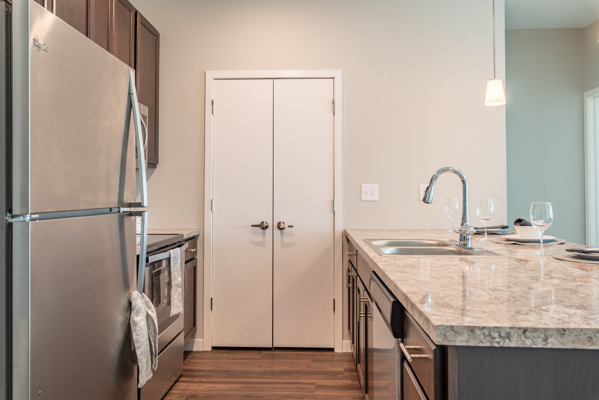 Kitchen with stainless steel appliances, hardwood floors, and a full-height pantry.