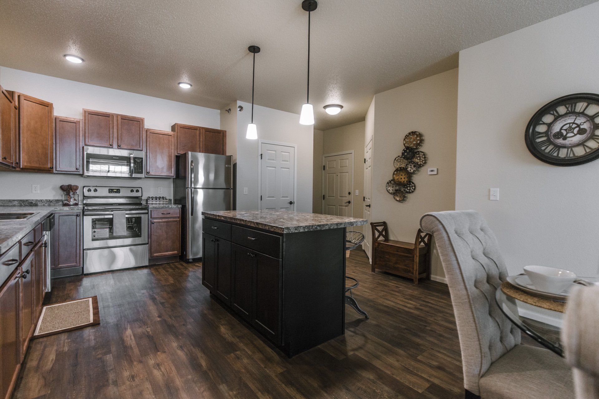 Alternate view of kitchen with granite counter island and stainless steel appliances