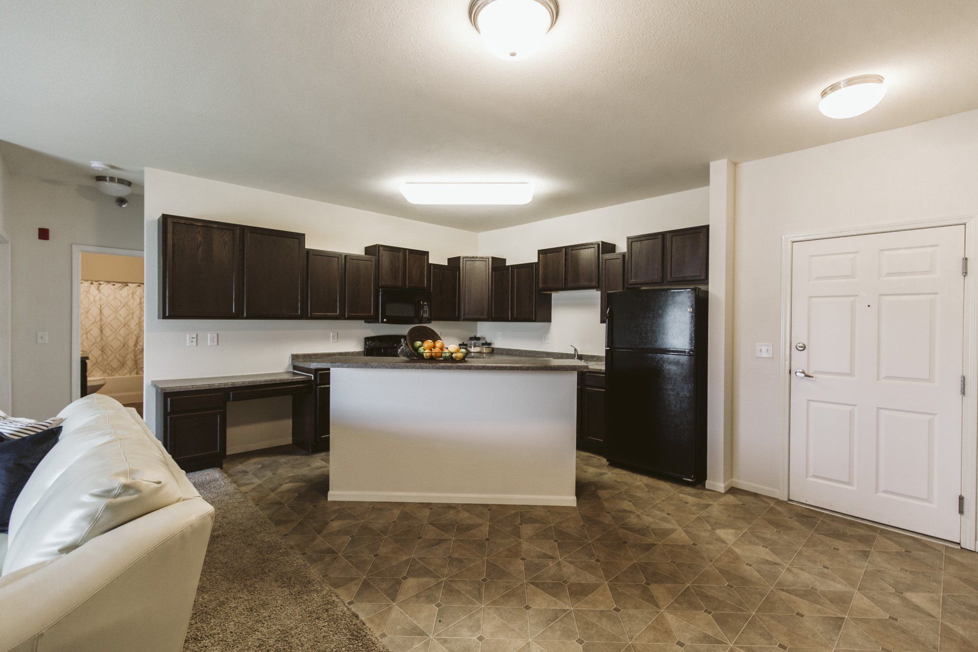 Kitchen with island in the center and doorway leading to bedroom