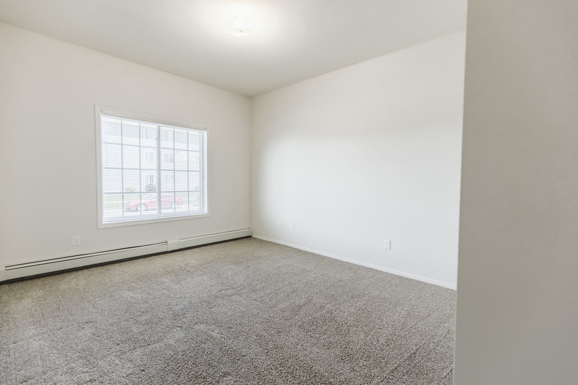 Carpeted bedroom with large horizontal window
