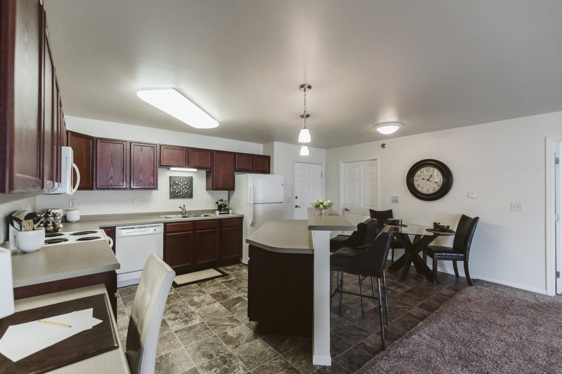 Alternate view of Large kitchen with dark wood cabinetry and white appliances
