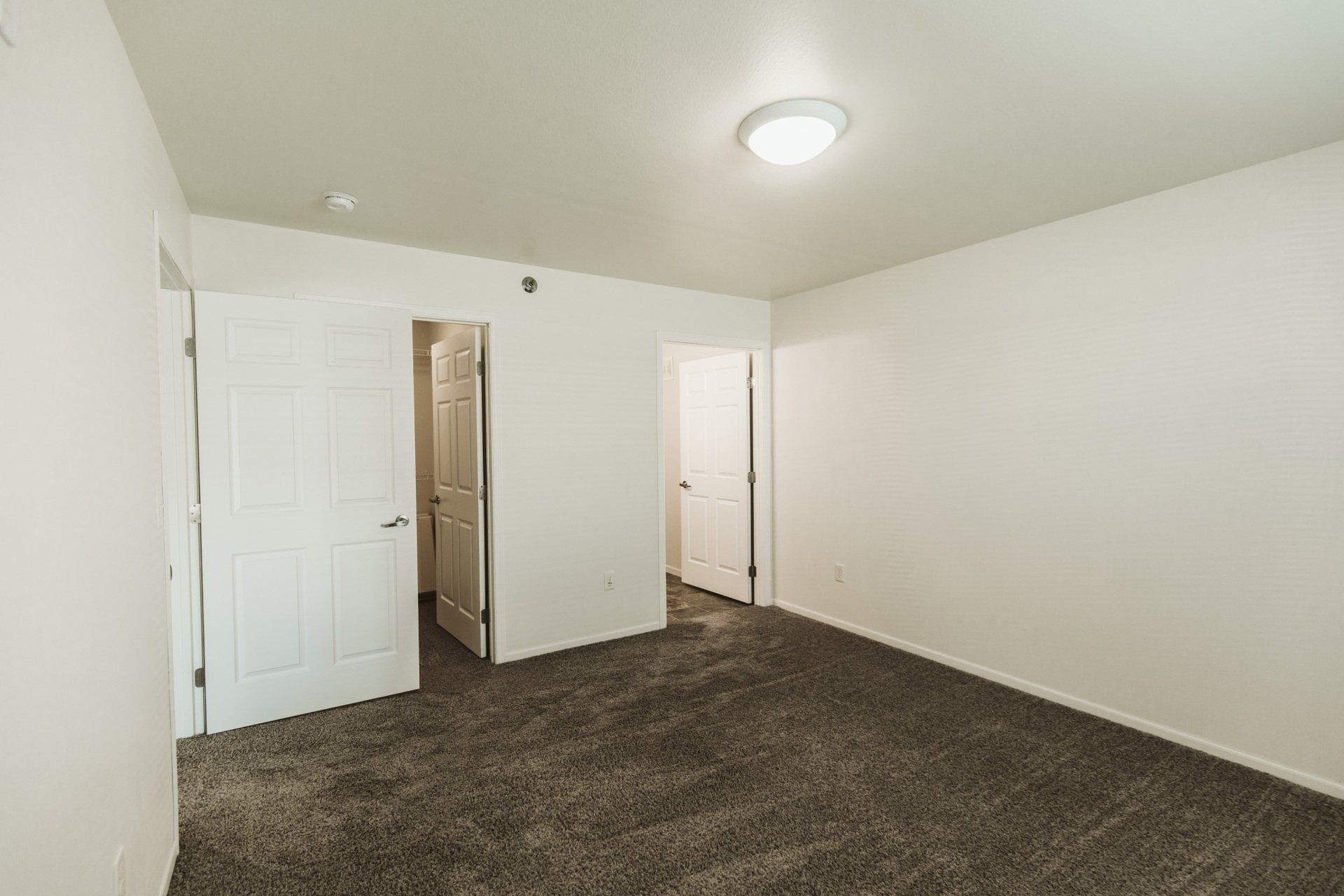 Alternate view of bedroom with doorways leading to closet and bathroom
