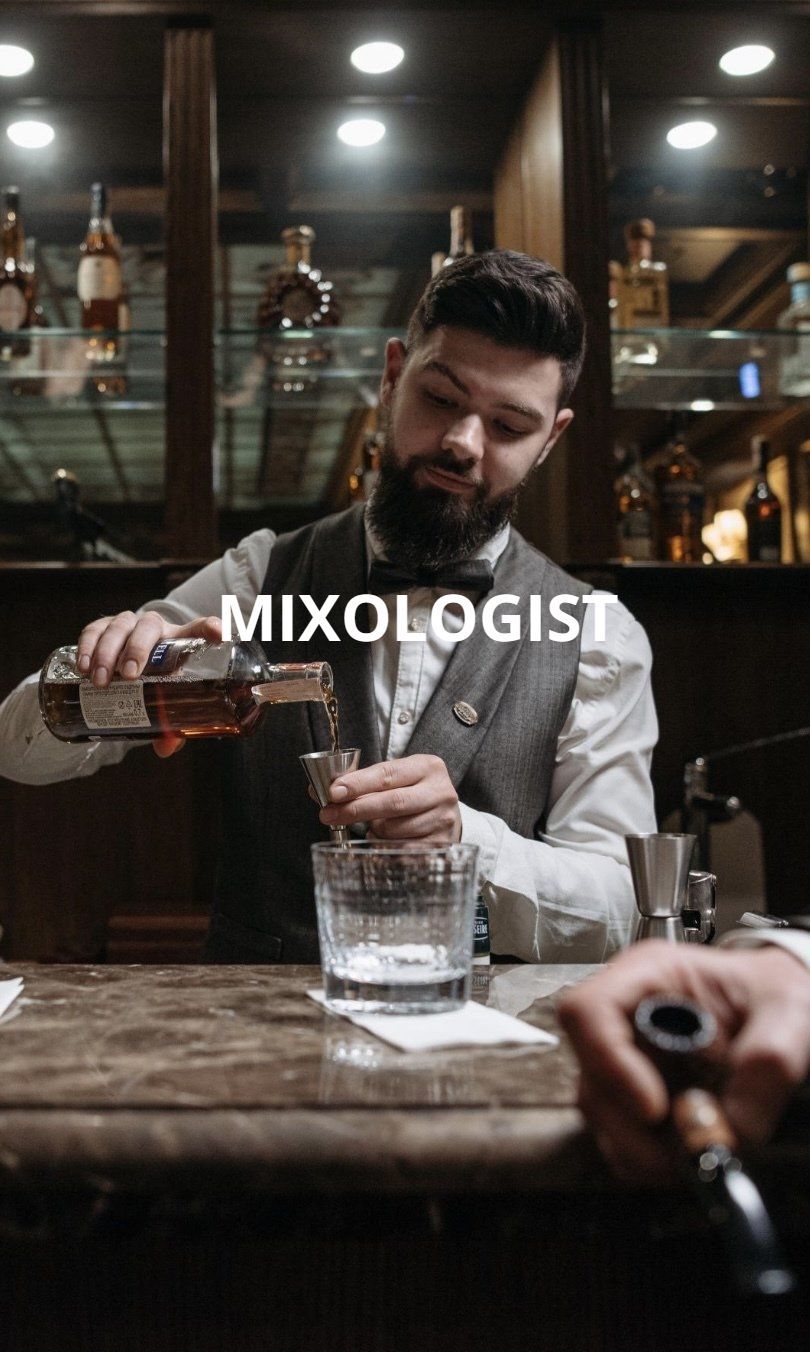 A bartender is pouring a drink into a glass at a bar.