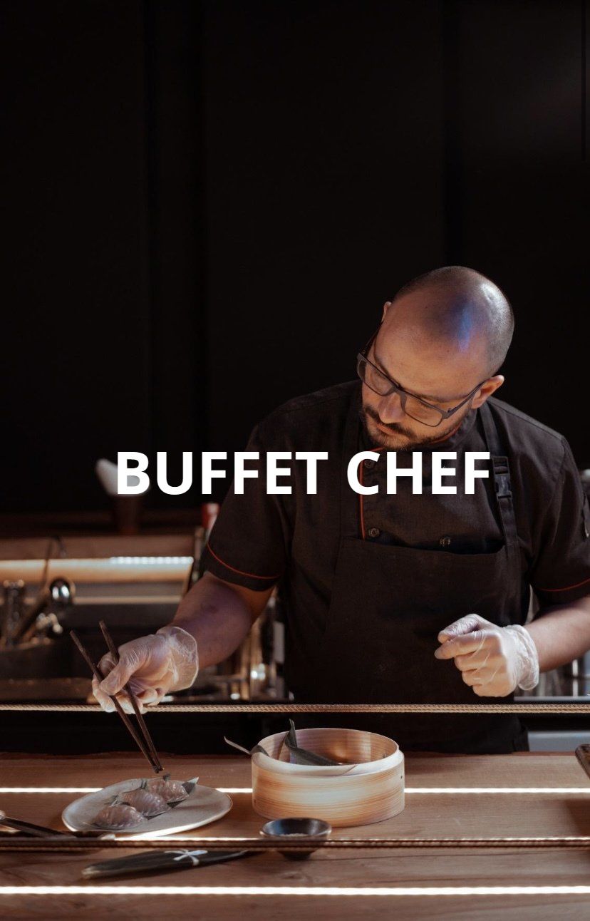 A man in a chef 's uniform is preparing food on a table.