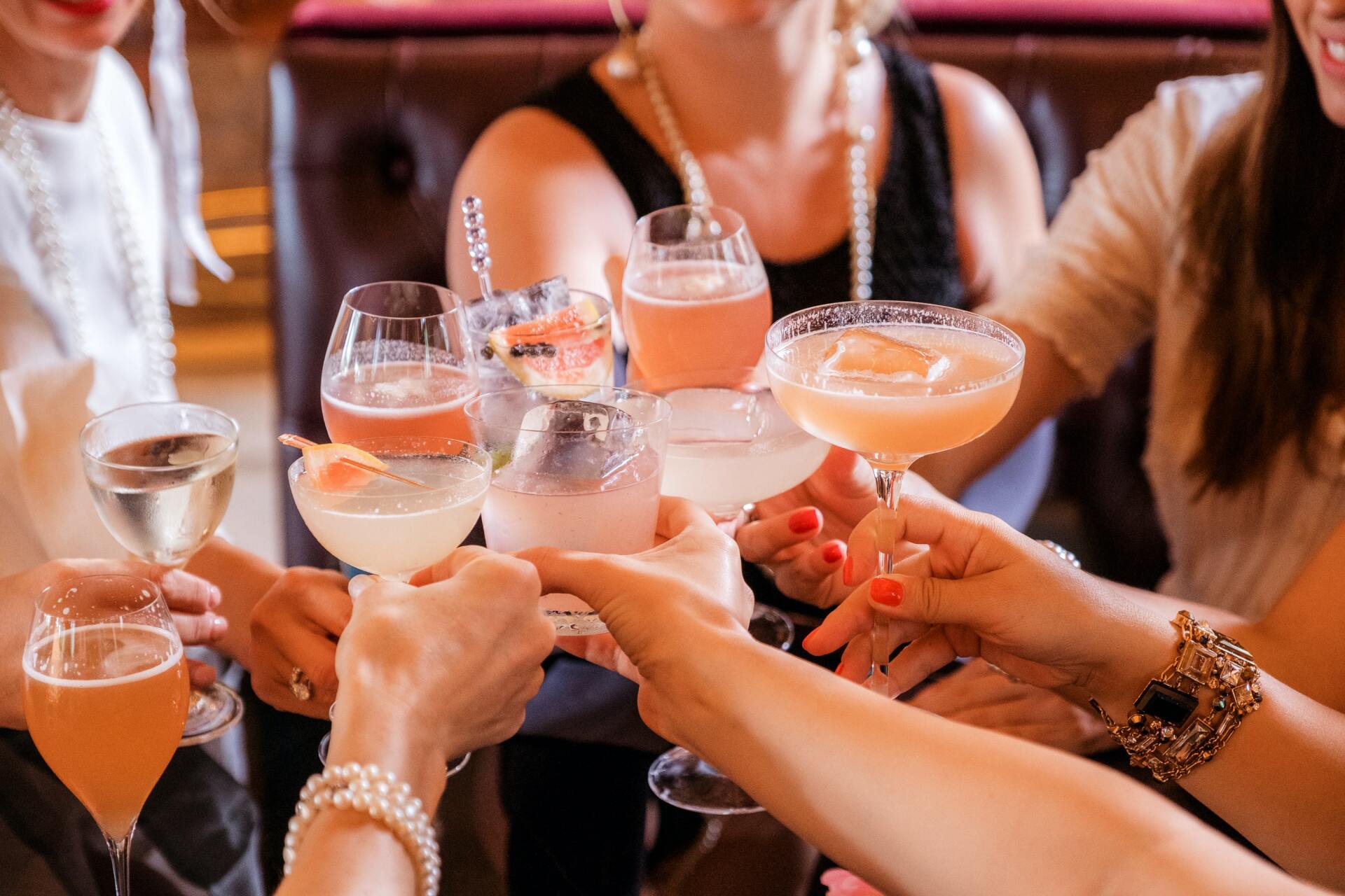 A group of women are toasting with their drinks