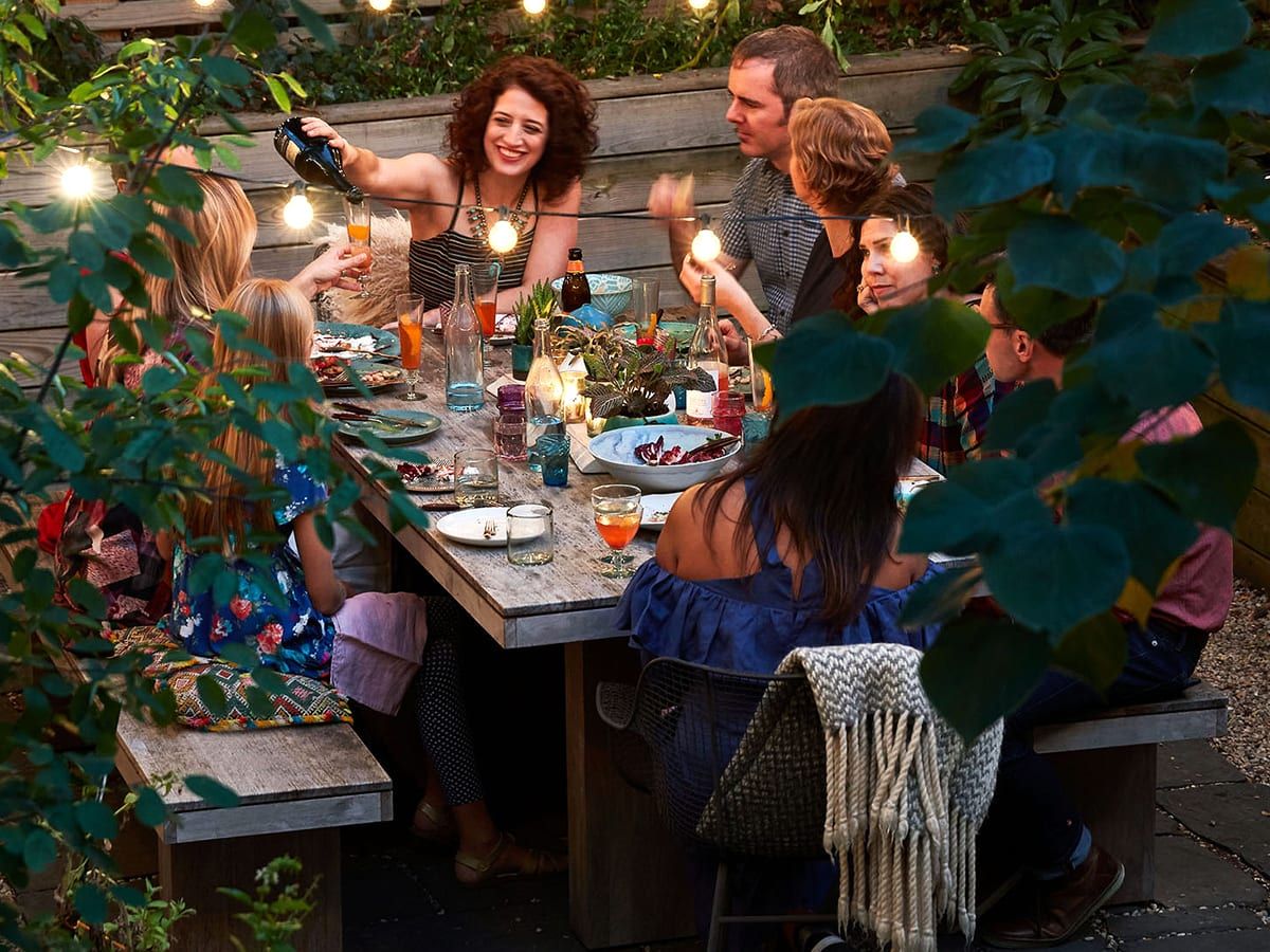 A group of people are sitting around a table eating and drinking