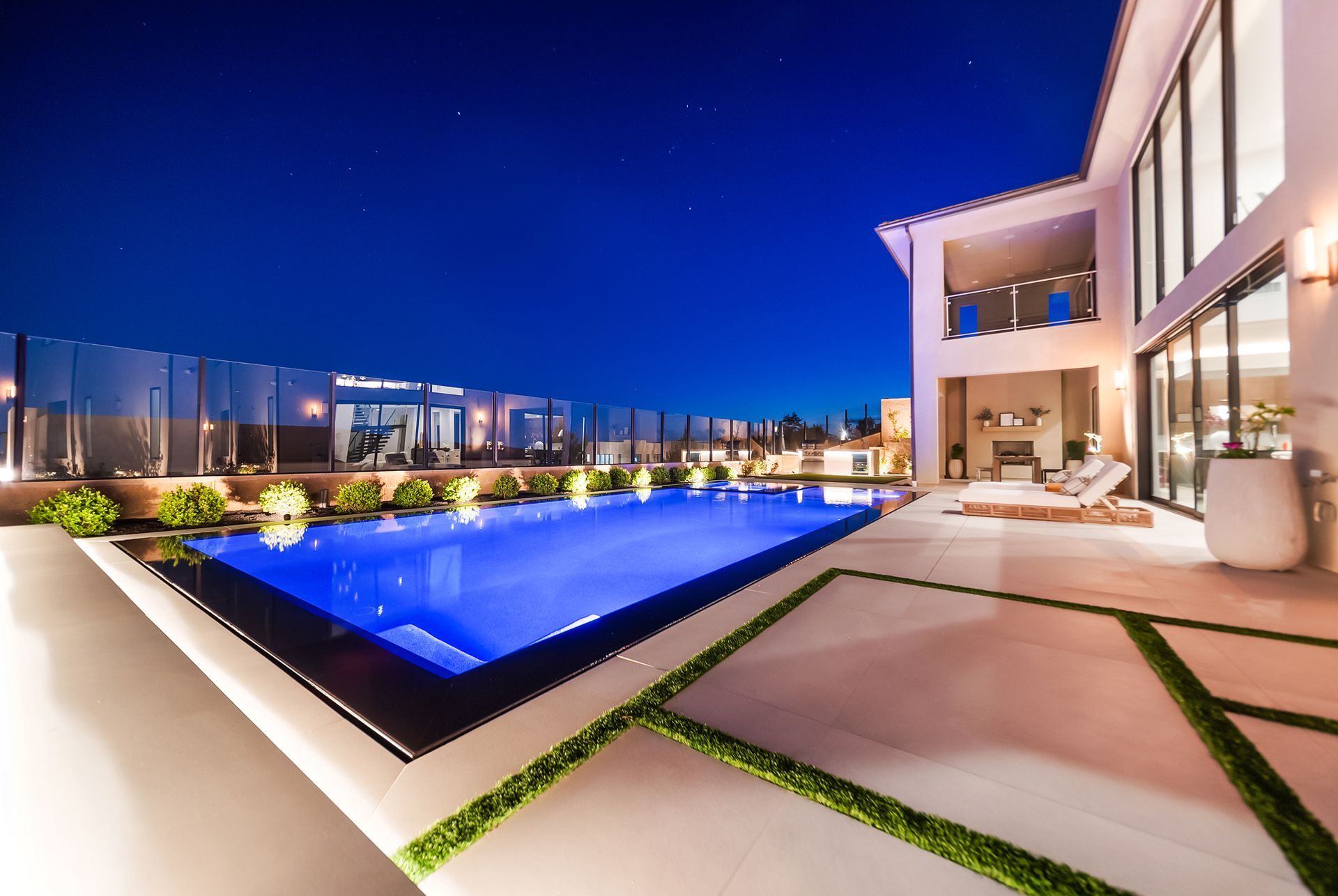 Luxury pool design and construction in Porter Ranch, Los Angeles. Design and build by Westmod. Night time photo of completed custom pool and outdoor living space.
